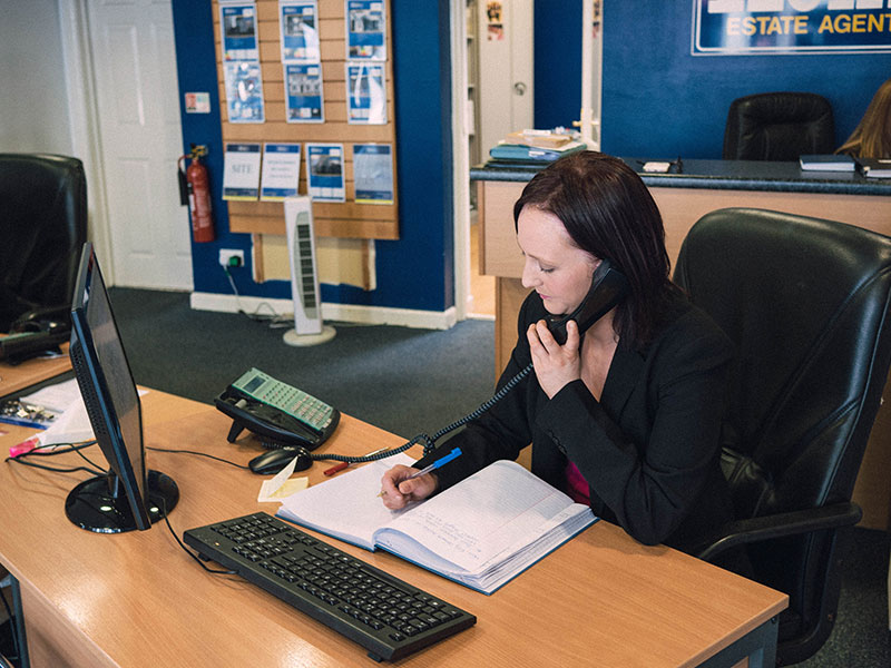 Daniel Henry Staff Member On The Phone With A Client Discussing The Sales Procedure