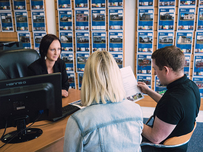 Daniel Henry Staff Member Disussing Mortgage Options With A Young Couple